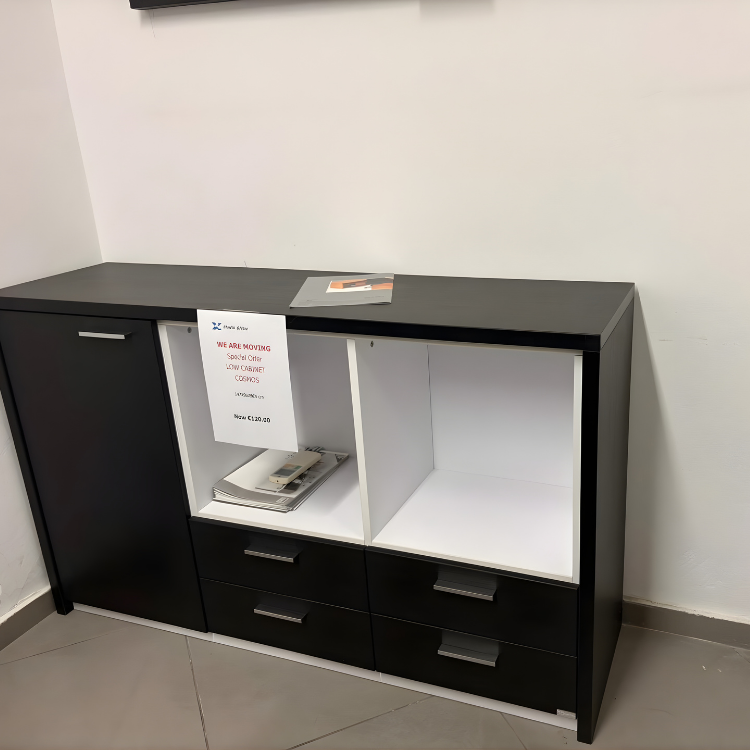 A black and white cabinet with drawers and open shelving sits against a white wall.