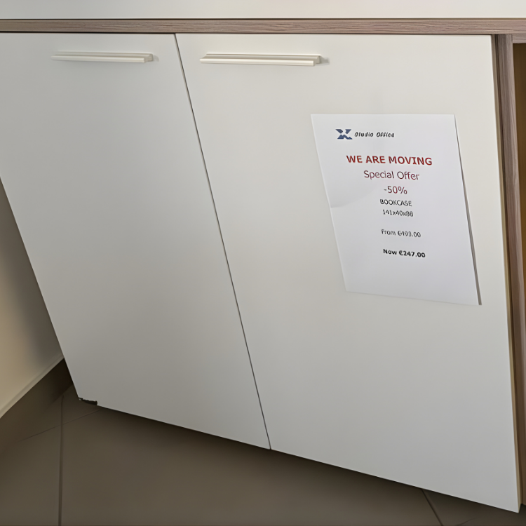 Белый шкаф с приклеенной к нему бумагой, рекламирующей специальное предложение на книжный шкаф.