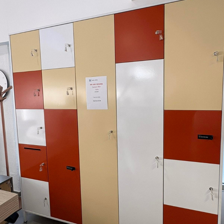 A multi-colored storage locker unit featuring white, beige, and red doors with individual locks and a combination lock.
