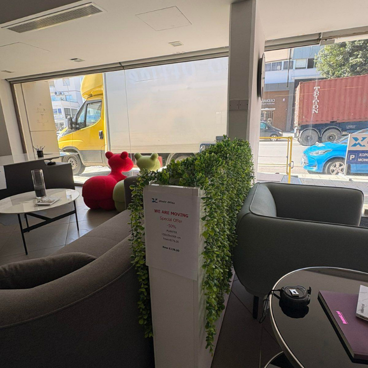 A showroom interior view shows furniture, a potted plant, and outdoor vehicles including a yellow van and a freight truck.
