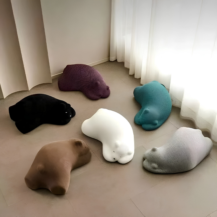 Several hippopotamus-shaped cushions in varied colors are arranged on a floor in a room setting.